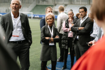 Menschen in Business Kleidung stehen auf dem Fußballfeld